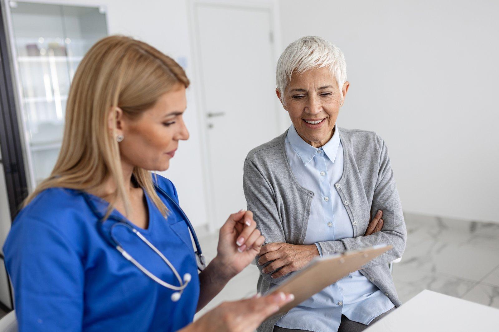 A nurse going through paperwork with an older patient