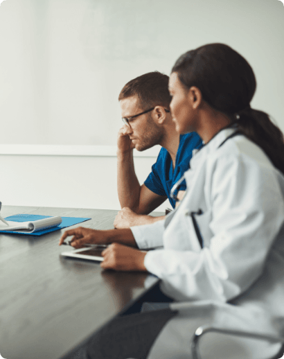 Two clinicians reviewing records at a desk