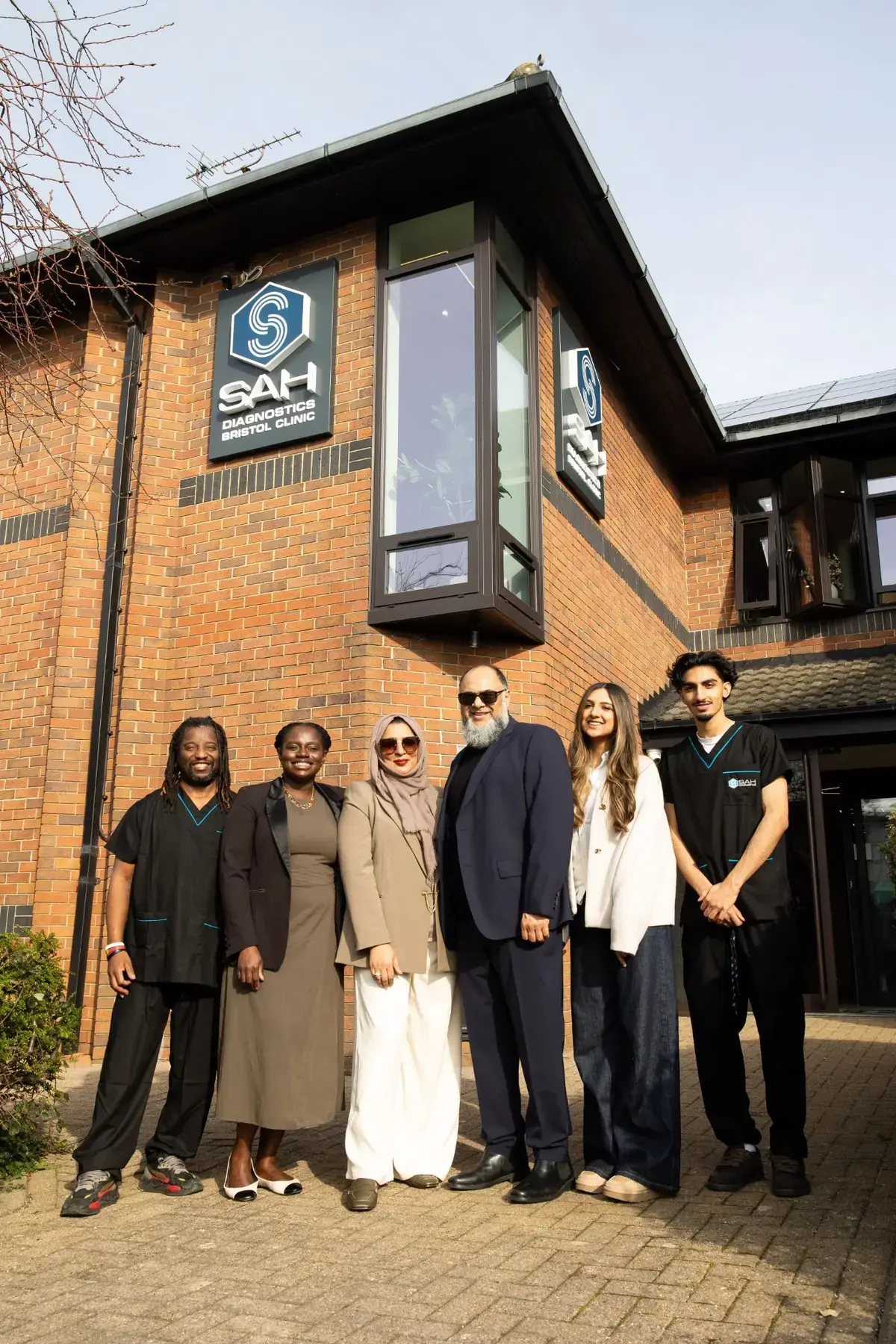 The SAH team outside the clinic, beneath the SAH Diagnostics Bristol Clinic sign