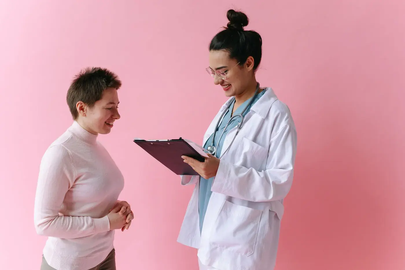 A doctor going through notes with a smiling patient
