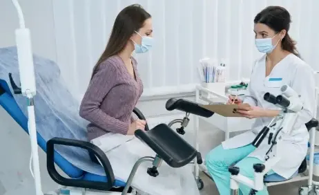 A clinician with a patient in a gynaecology examination room