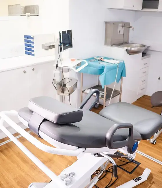 The procedure room inside the unit, with a procedure chair and a sterile trolley